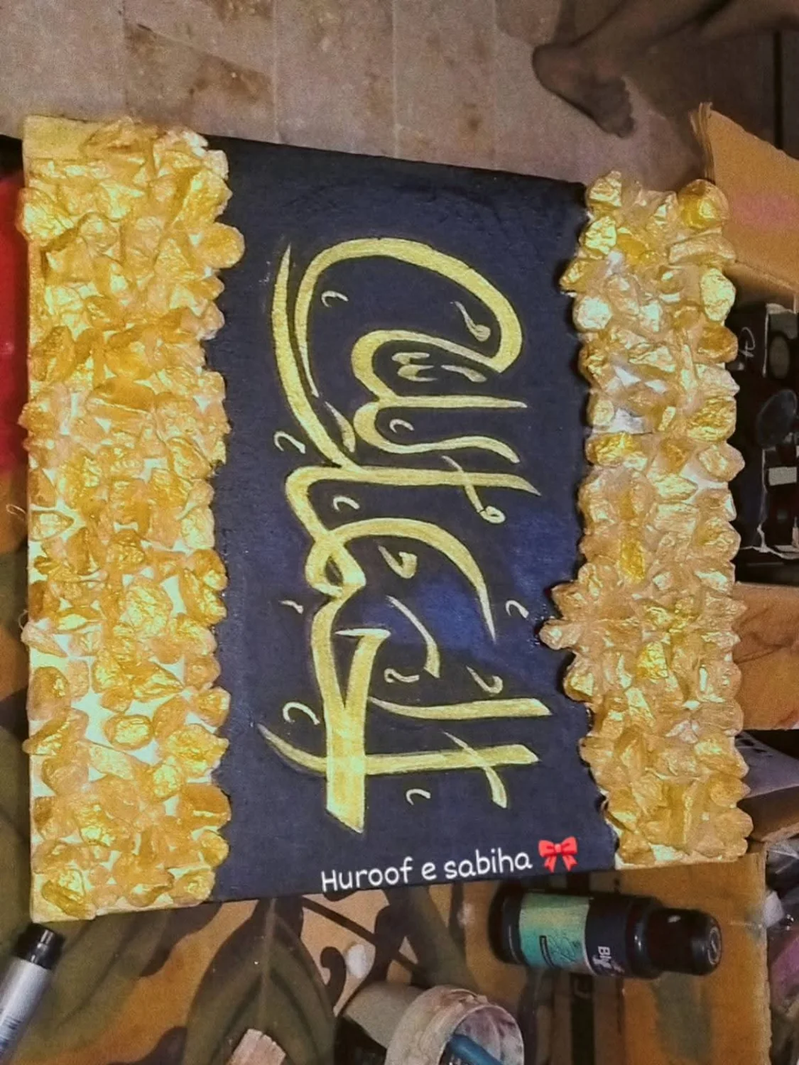 Gold Arabic calligraphy artwork on dark canvas